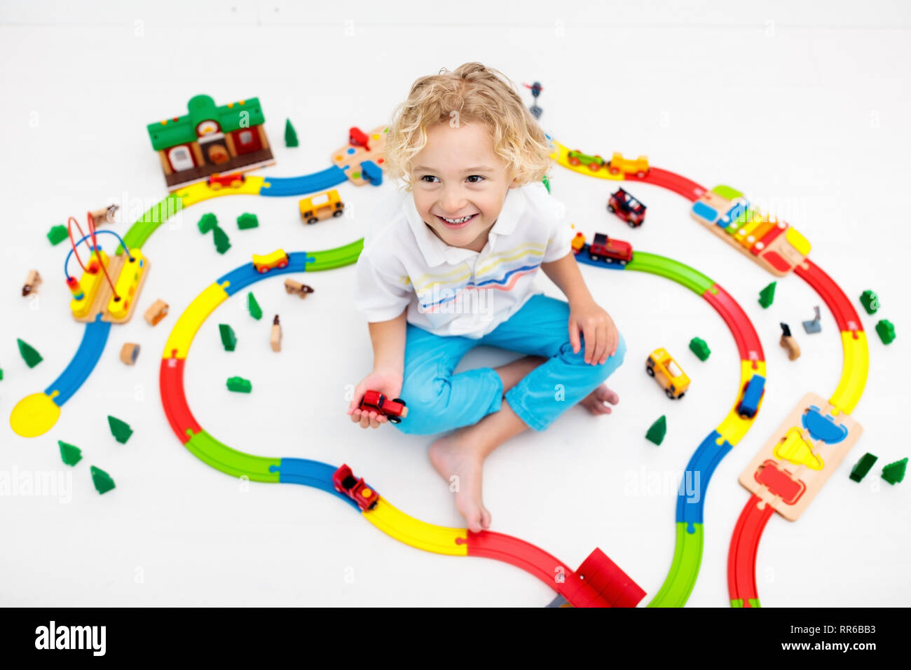 Kids play with toy train railway. Child playing with colorful rainbow