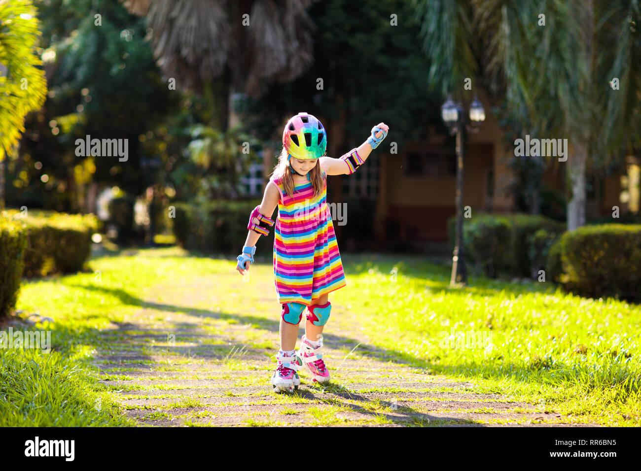 Child on inline skates in park. Kids learn to skate roller blades