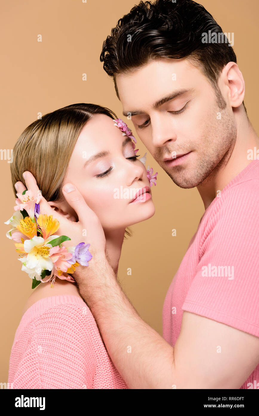 handsome boyfriend touching face of girlfriend with flowers on face  isolated on beige Stock Photo - Alamy