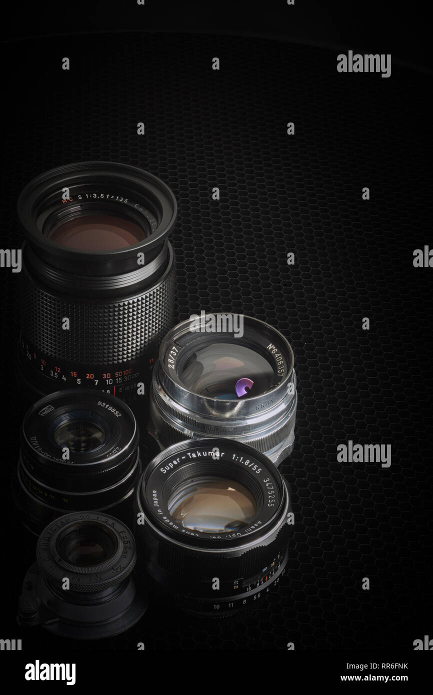 Collection of vintage M42 lenses against a black background, vertical apsect. Stock Photo
