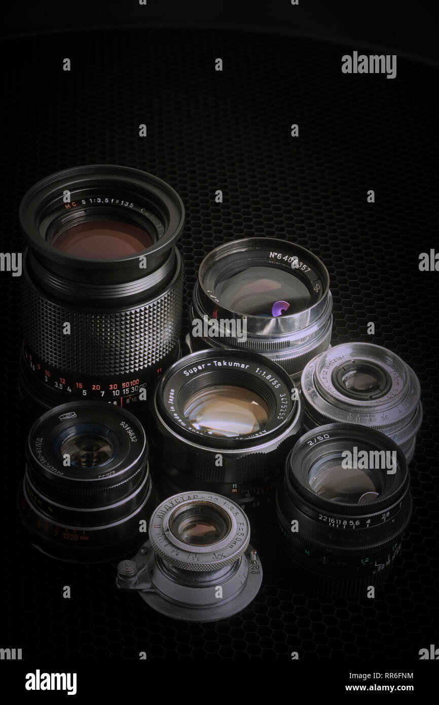 Collection of vintage M42 lenses against a black background, vertical apsect. Stock Photo