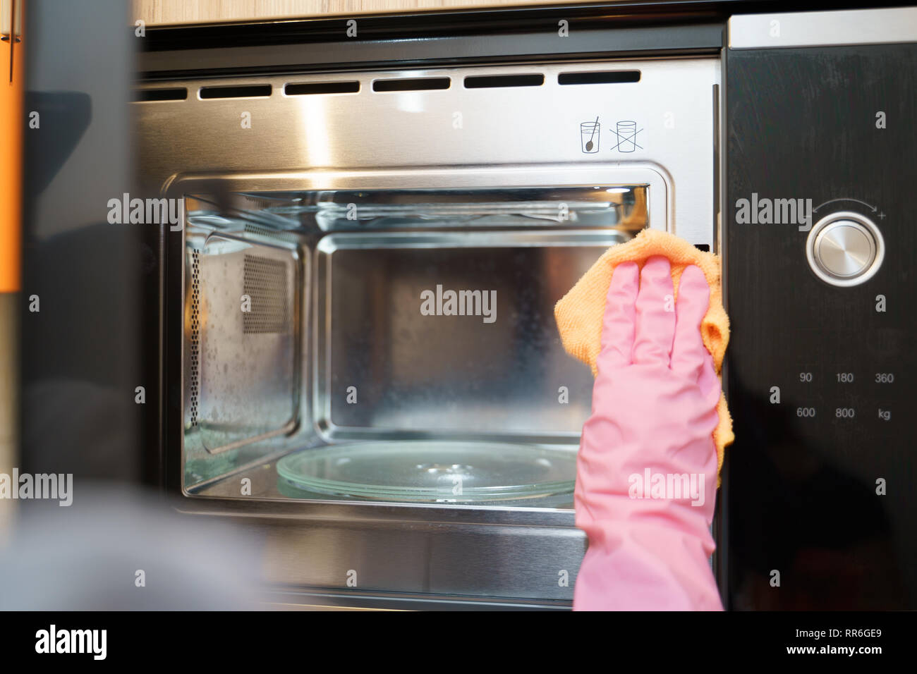 Picture of hands in rubber gloves washing microwave Stock Photo