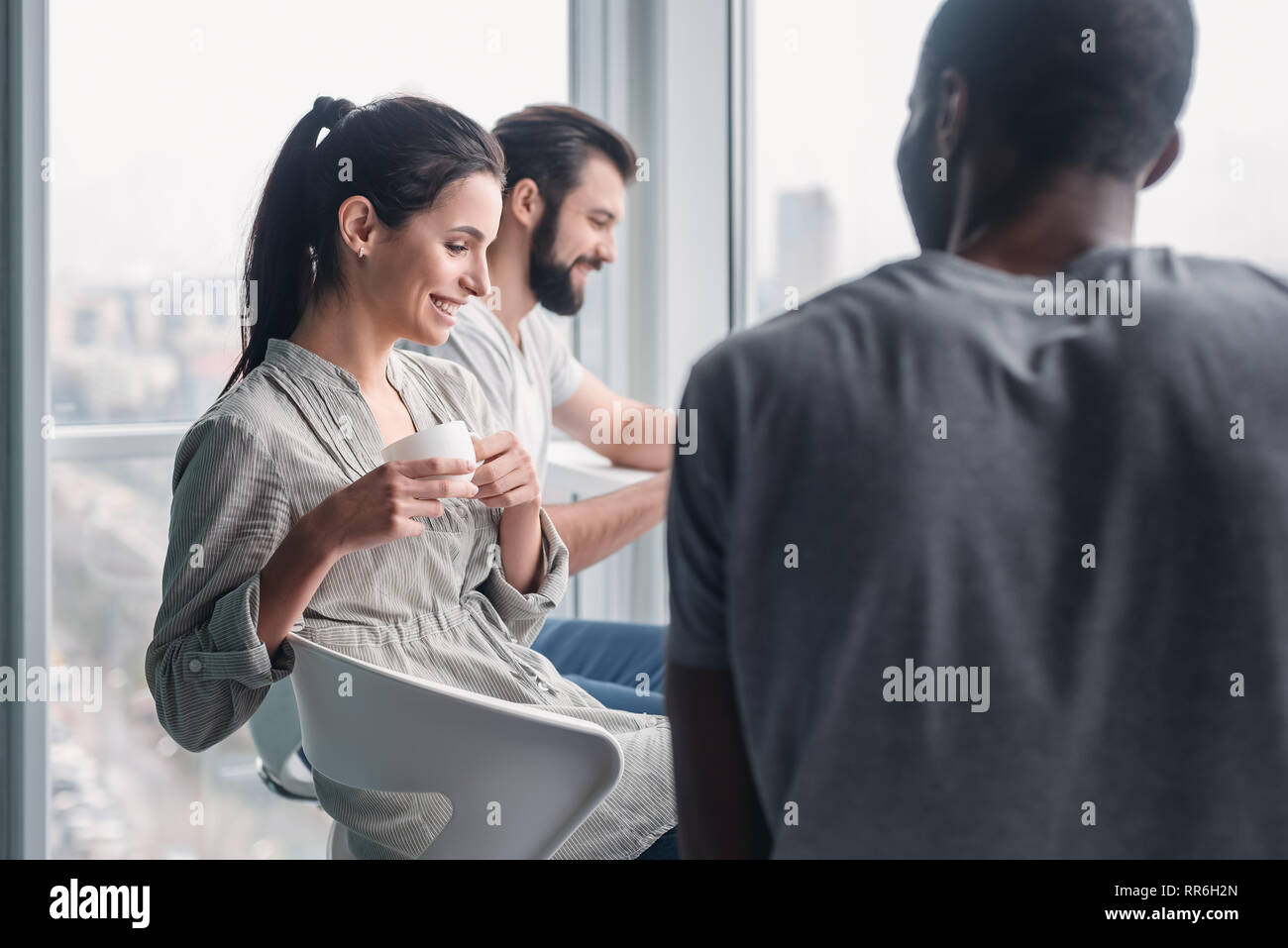 Happy joyful diverse business people laughing at funny joke talking at work break, cheerful corporate team office workers multi-ethnic young coworkers having fun, engaged in teambuilding activity Stock Photo