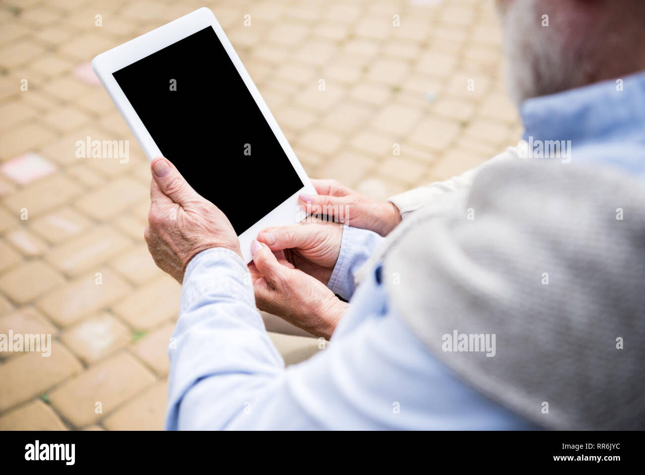 senior couple using digital tablet while sitting together Stock Photo
