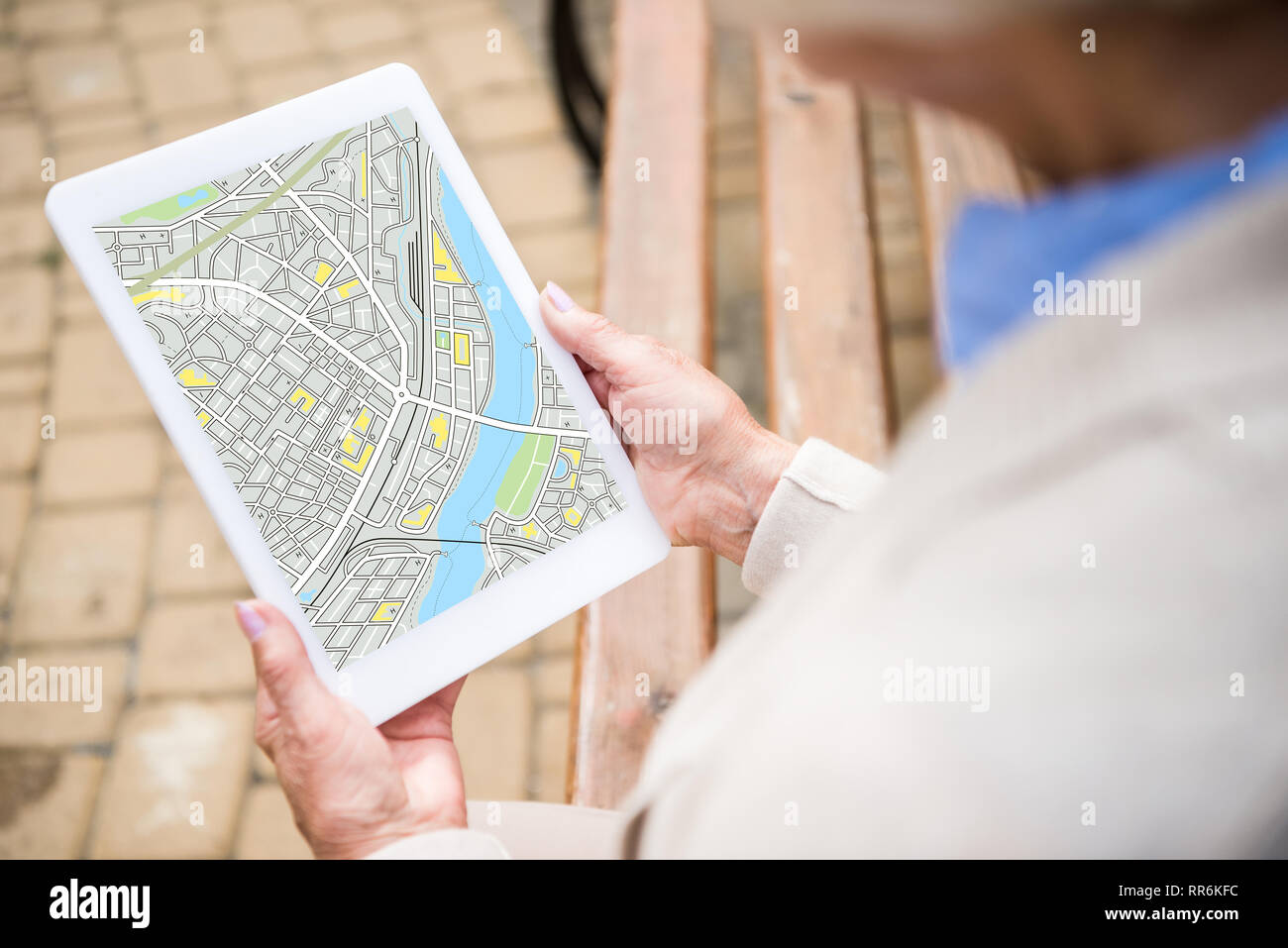 selective focus of senior woman holding digital tablet with map on screen Stock Photo