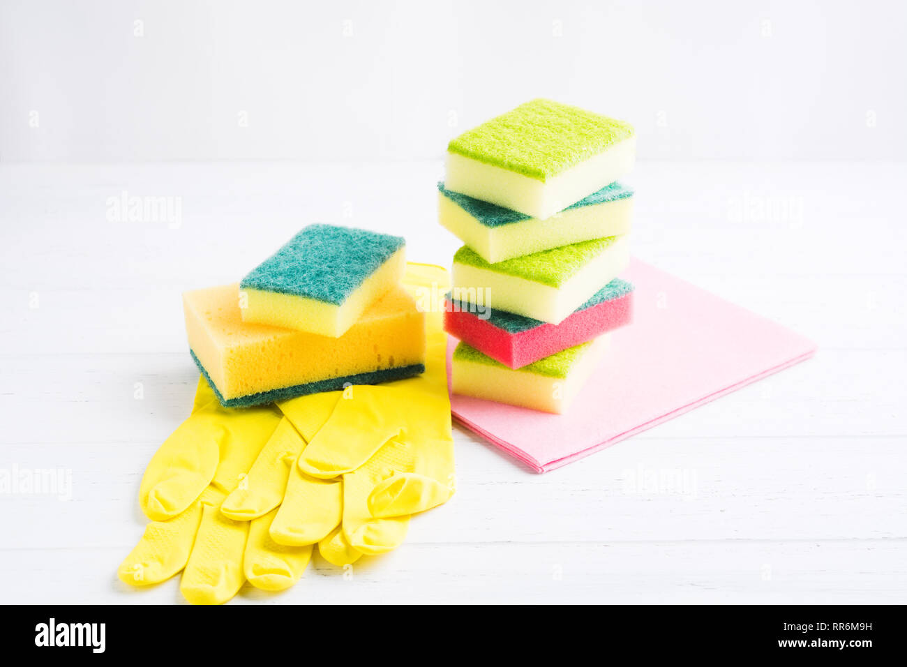 Sponges, washcloth, rubber gloves for domestic housework. Home hygiene concept on wooden table Stock Photo