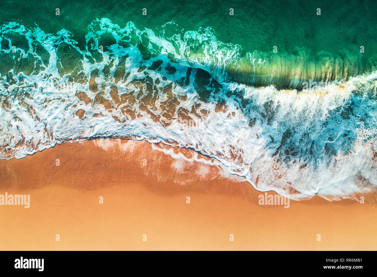 Aerial view of sea waves and sandy beach. Stock Photo