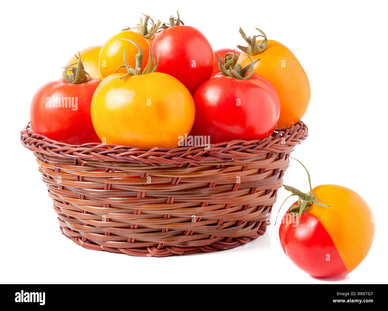 red and yellow tomatoes in a wicker basket isolated on white background ...