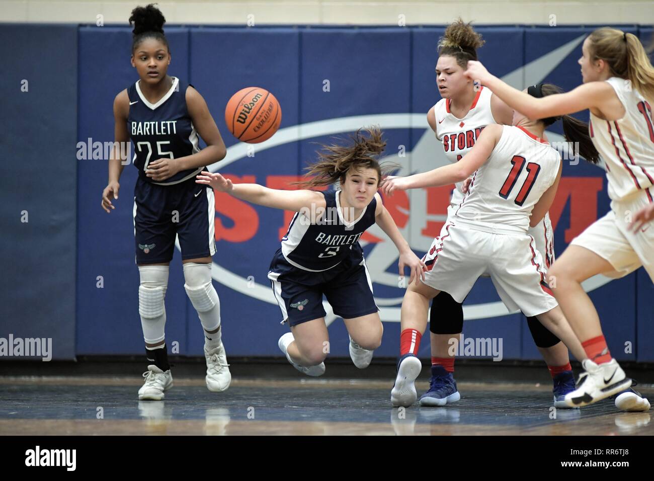 Player being fouled and sent sprawling under her own basket while
