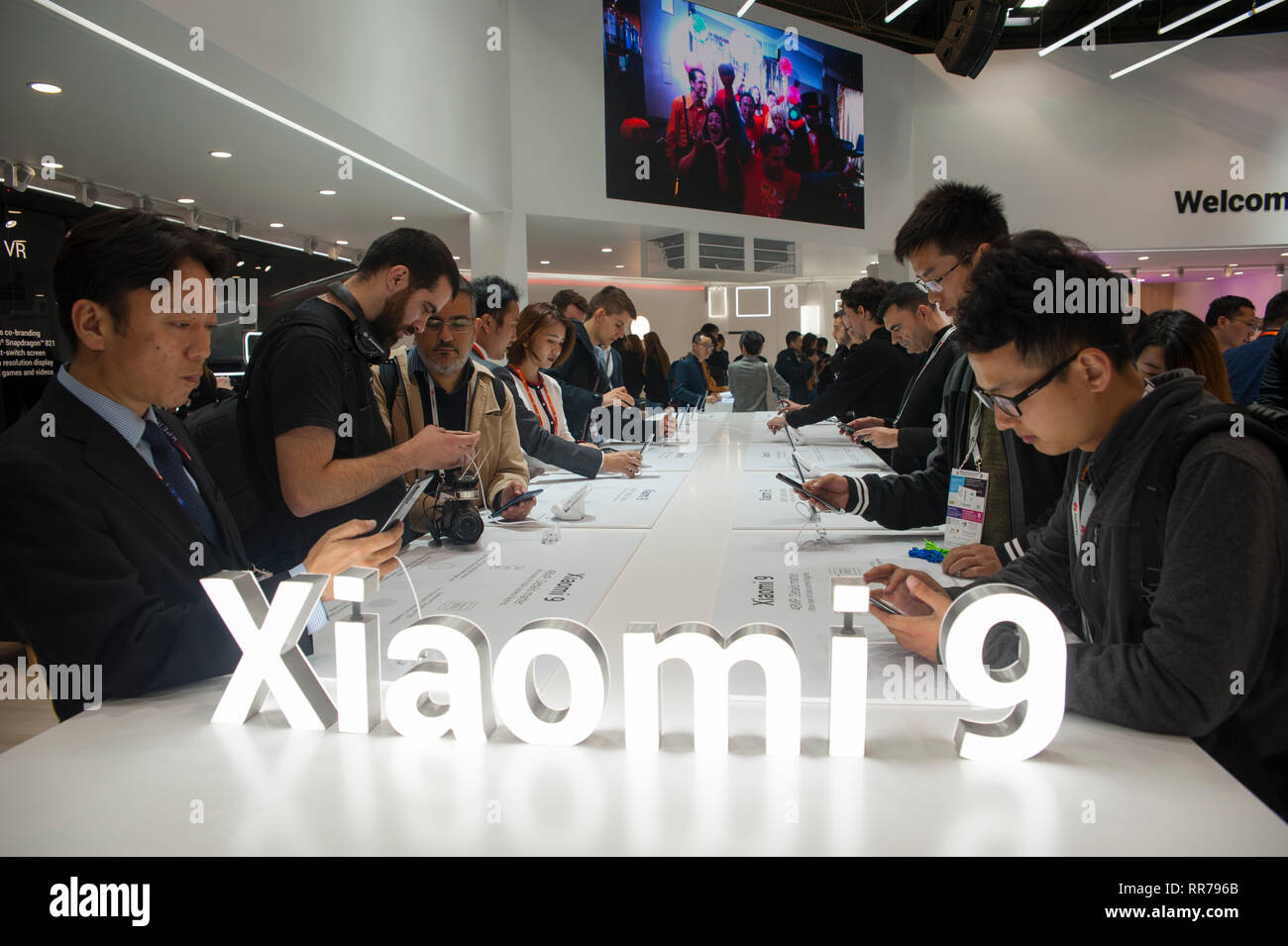 Barcelona, Spain, Monday, Feb. 25, 2019. Mobile World Congress attendees examine the new terminal of Xiaomi the Mi 9 with three cameras and integrated fingerprint reader on the screen is consolidated as the company's flagship for this 2019. The mobile congress will revolve around intelligent connectivity and address hyperconnectivity, 5G, the internet of things, artificial intelligence (AI) and big data. Credit: Charlie Perez/Alamy Live News Stock Photo