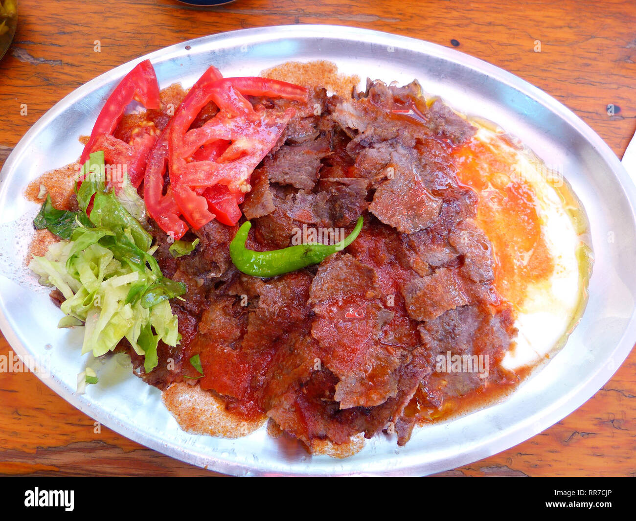 Plate of iskender doner kebap with yoghurt and salad. Stock Photo