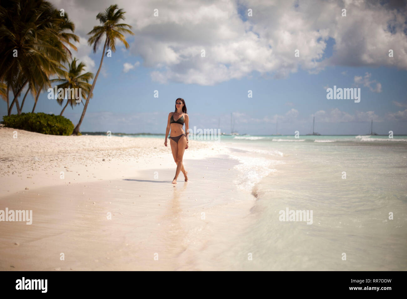 Woman walks on a tropical beach Stock Photo