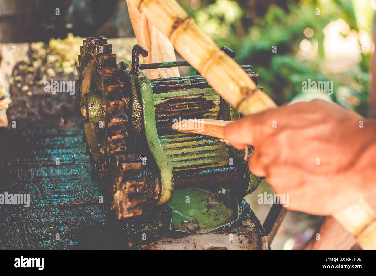 Man doing sugarcane juice on a old manual machine Stock Photo