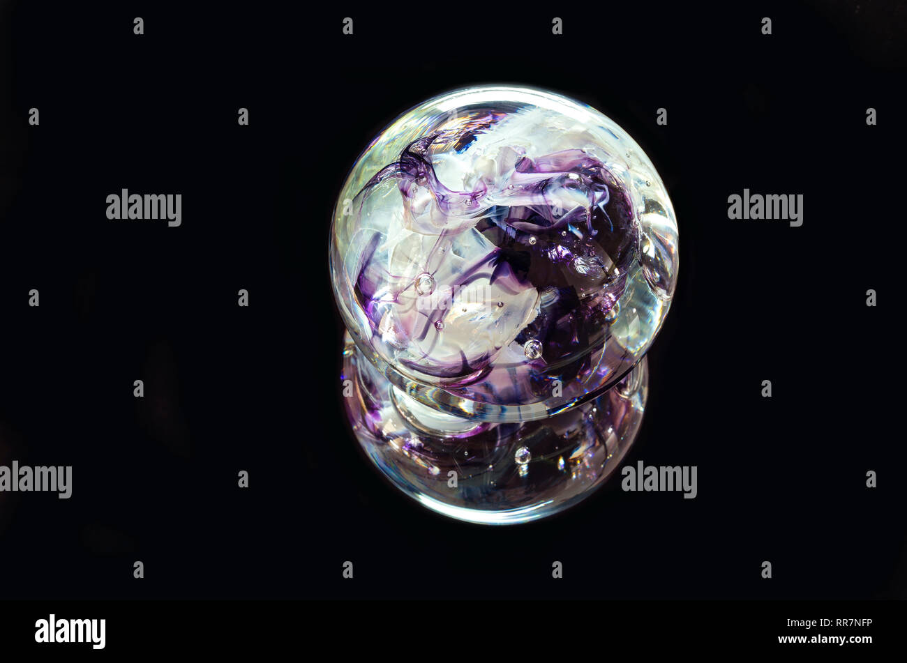 textured glass paperweight and reflection isolated against black Stock Photo