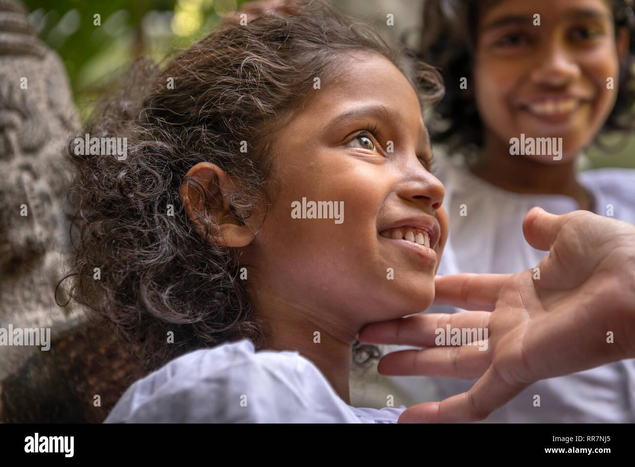 A little girl takes time out from Sunday School at the Gangaramaya Buddhist Temple in Colombo Sri Lanka. Stock Photo
