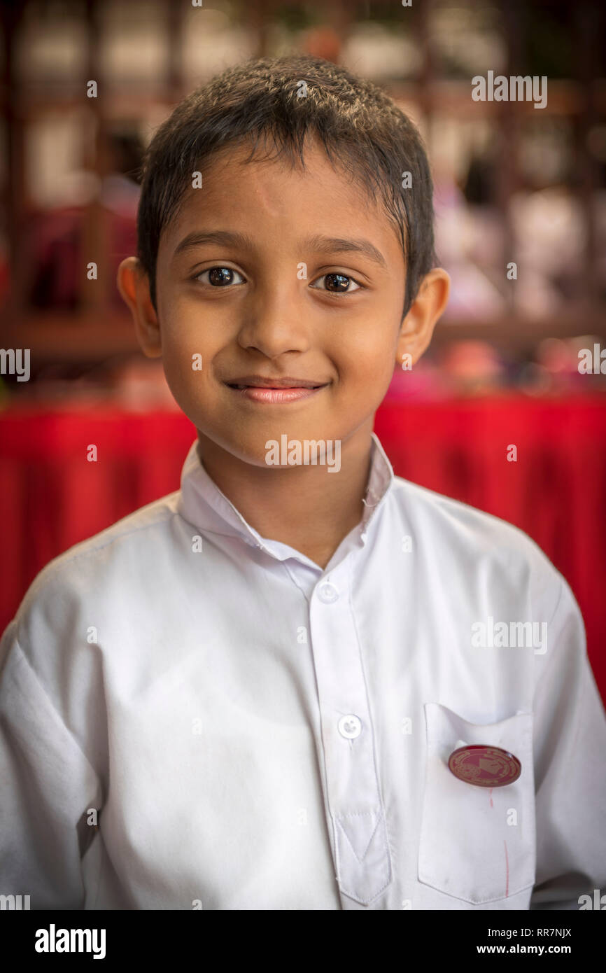 A little boy poses for the camera at Gangaramaya Buddhist Temple in Colombo Sri Lanka. Stock Photo