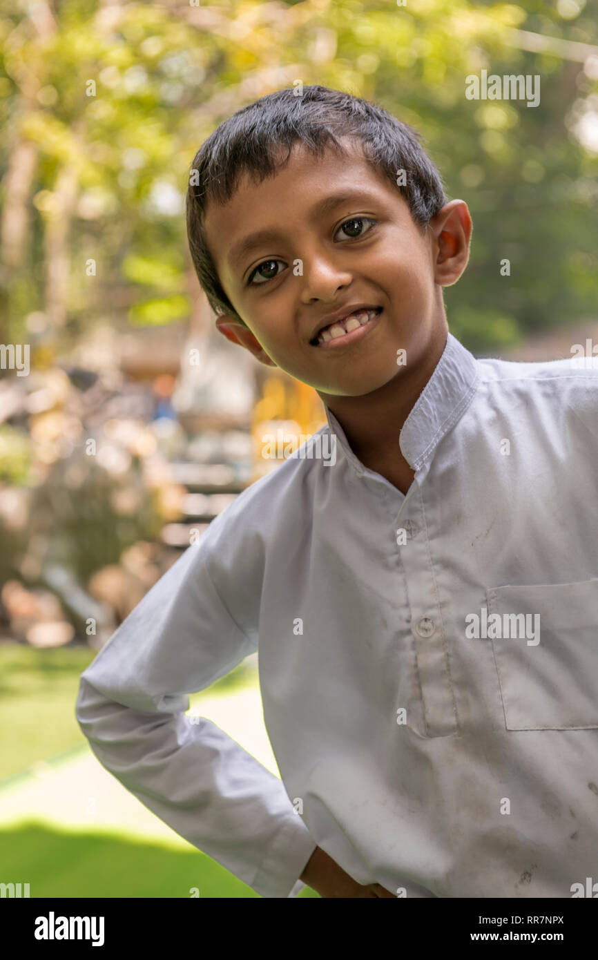 A young boy poses for the camera at Gangaramaya Buddhist Temple in Colombo Sri Lanka. Stock Photo