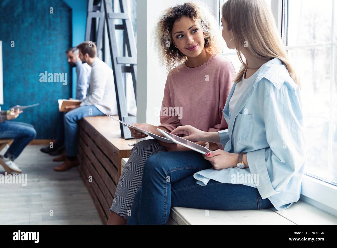 Creative female designers working in team. Two Businesswomen Having Informal Meeting In Modern Office. Stock Photo