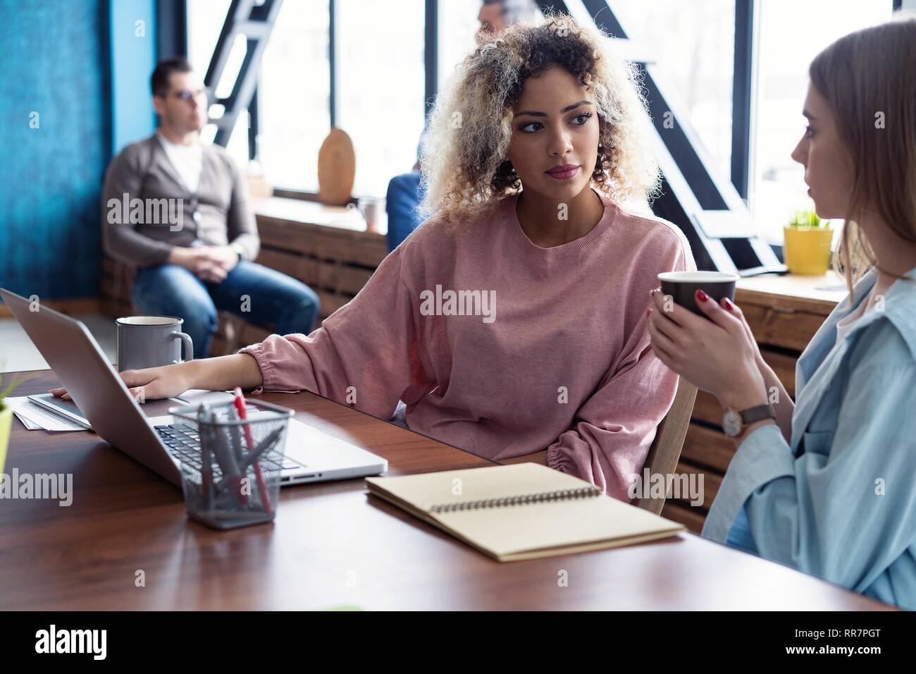 Creative female designers working in team. Two Businesswomen Having Informal Meeting In Modern Office. Stock Photo