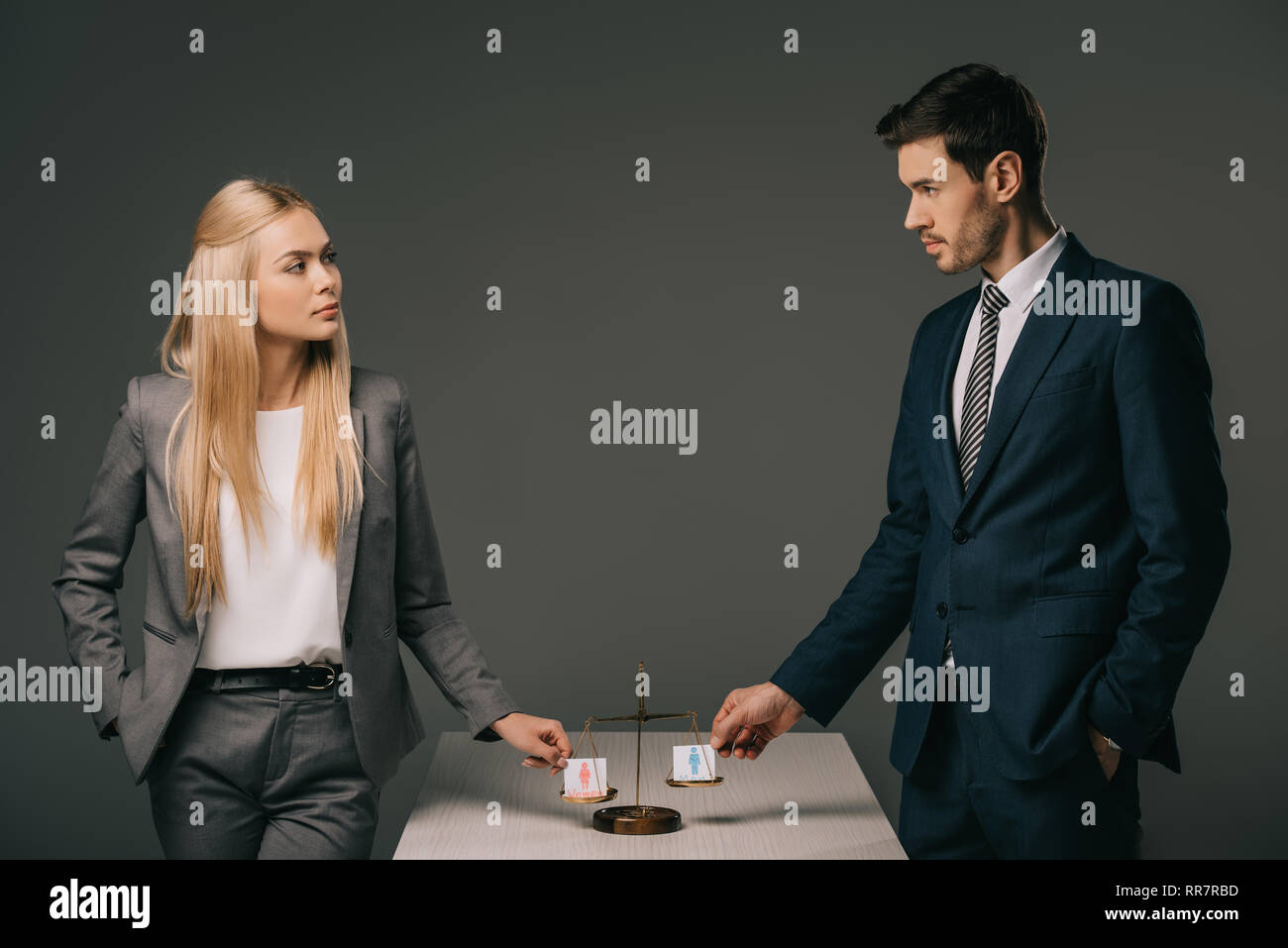 business colleagues with male and female signs on scales of justice