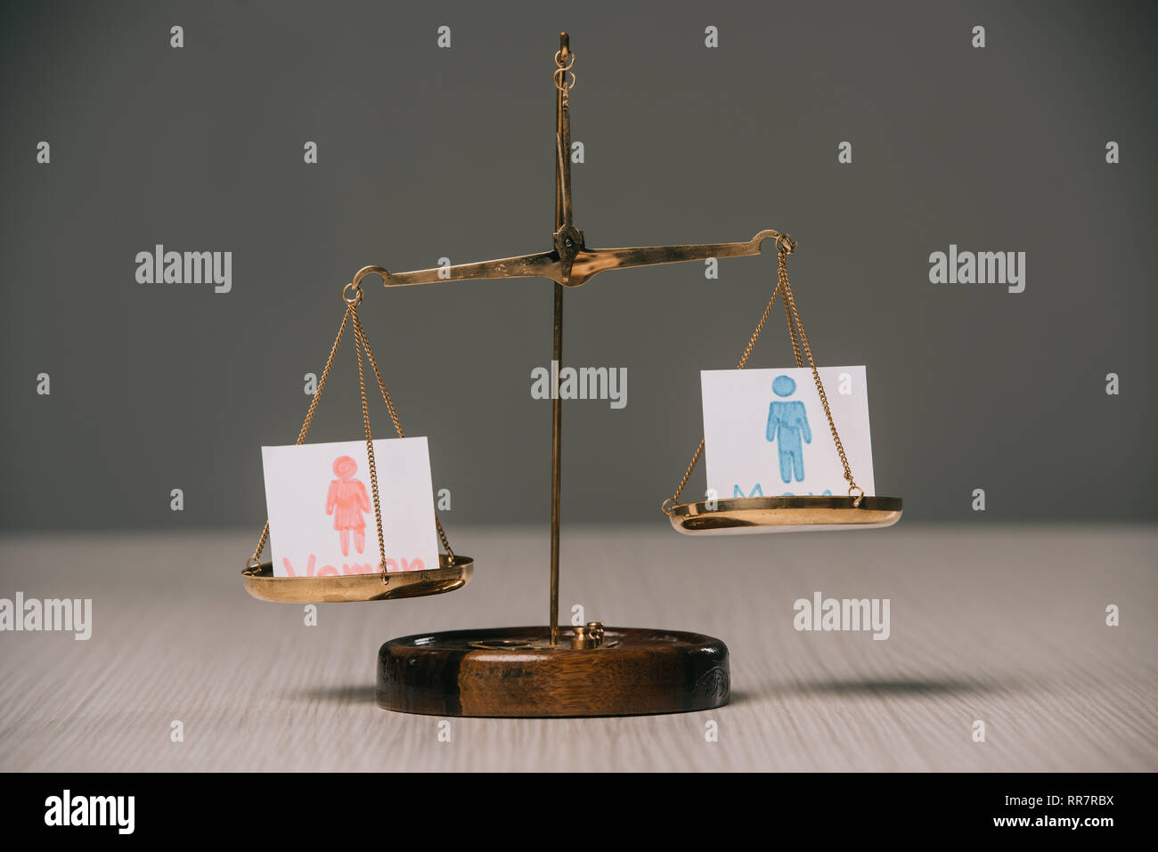 male and female signs on scales on wooden table, gender equality concept Stock Photo