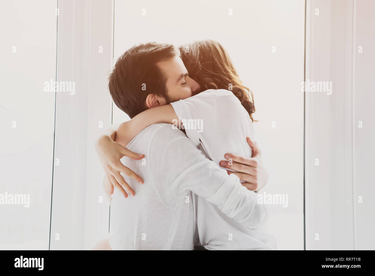 beautiful young couple passionately hugging with sunlight on background  Stock Photo - Alamy, image size:1300x957