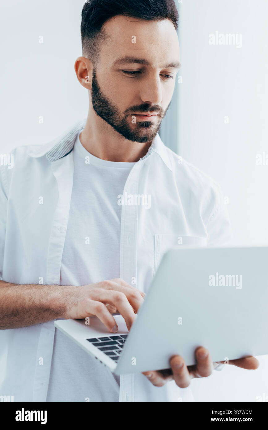 Handsome young man with beard holding laptop Stock Photo