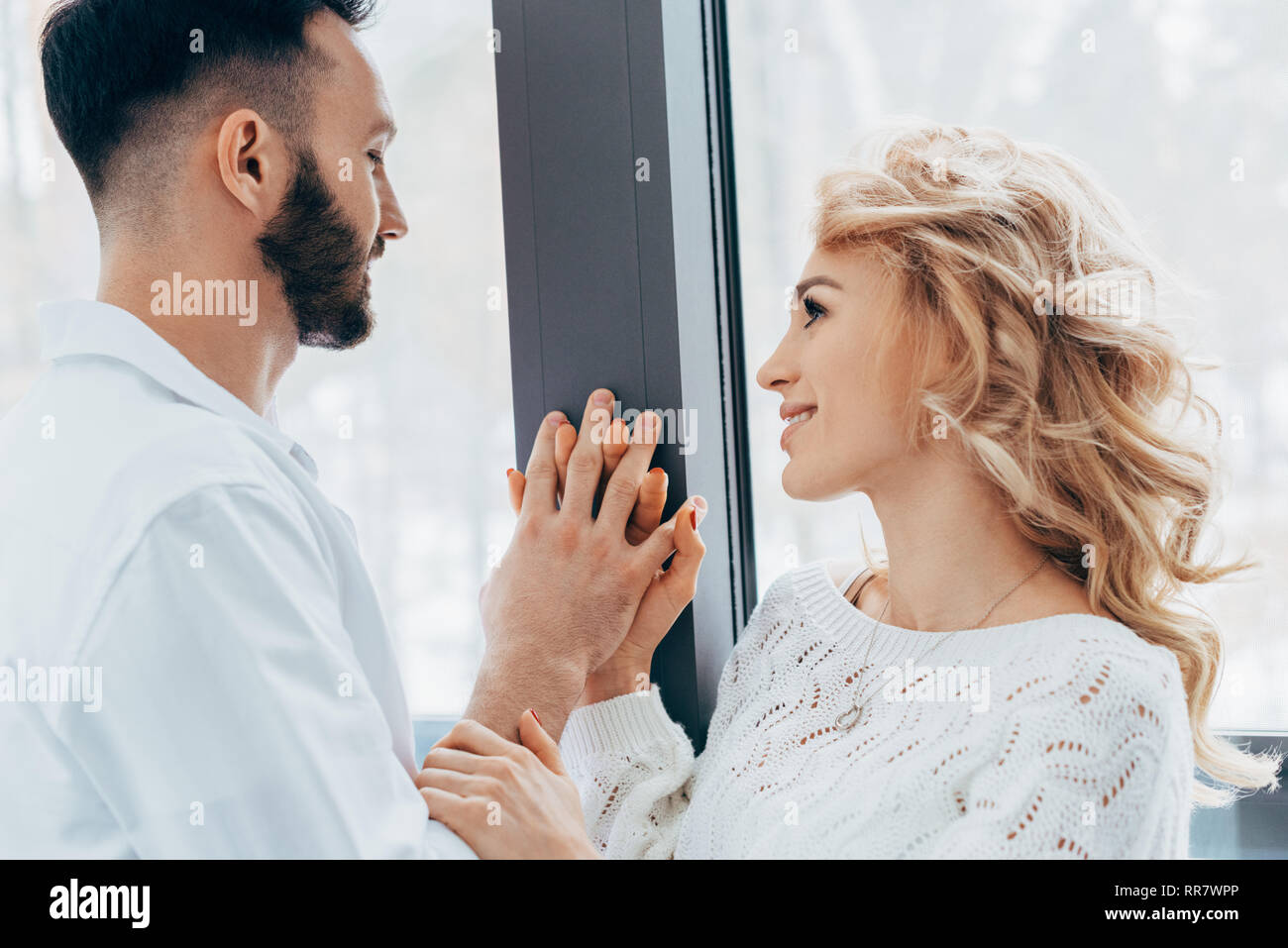 Happy couple holding hands and looking at each other with love Stock ...