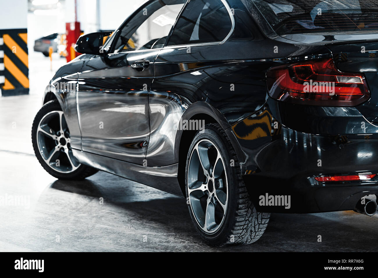 Modern car exterior. Driver's door, back mirror, wheels. Luxury black