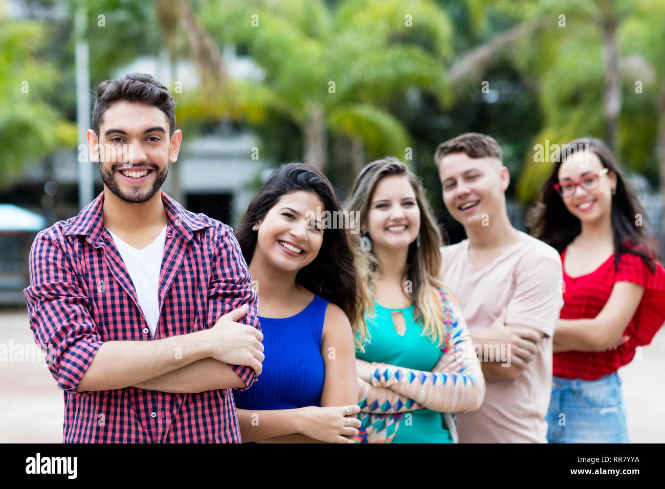 Spanish hipster man with male and female young adults in line outdoor in the city Stock Photo