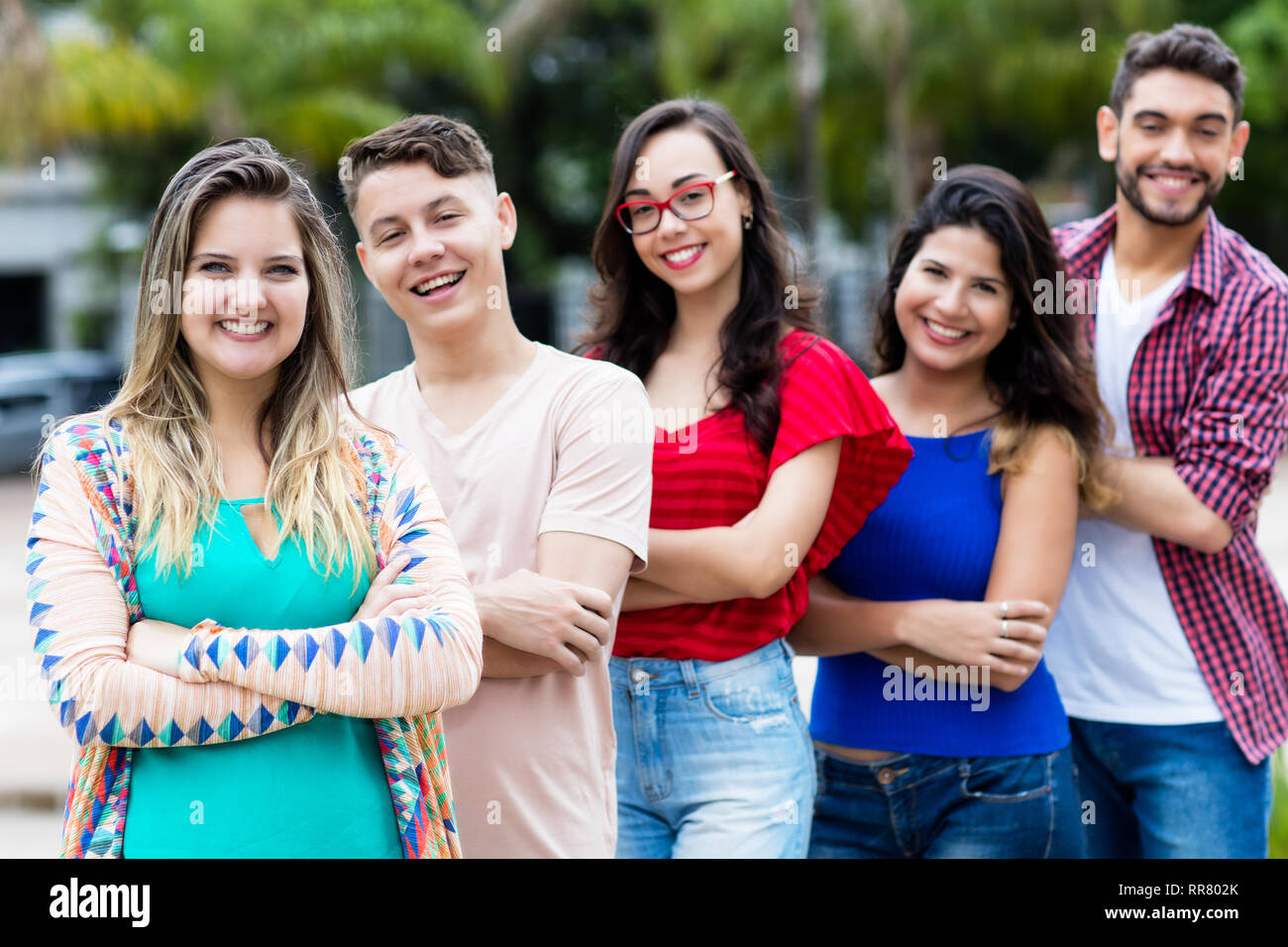German girl with male and female young adults in line outdoor in the city Stock Photo