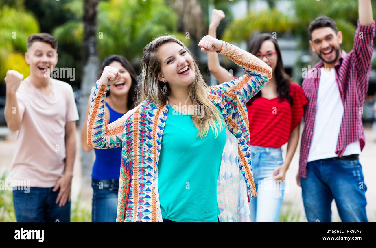 Cheering german girl with happy group of friends outdoor in the summer in the city Stock Photo