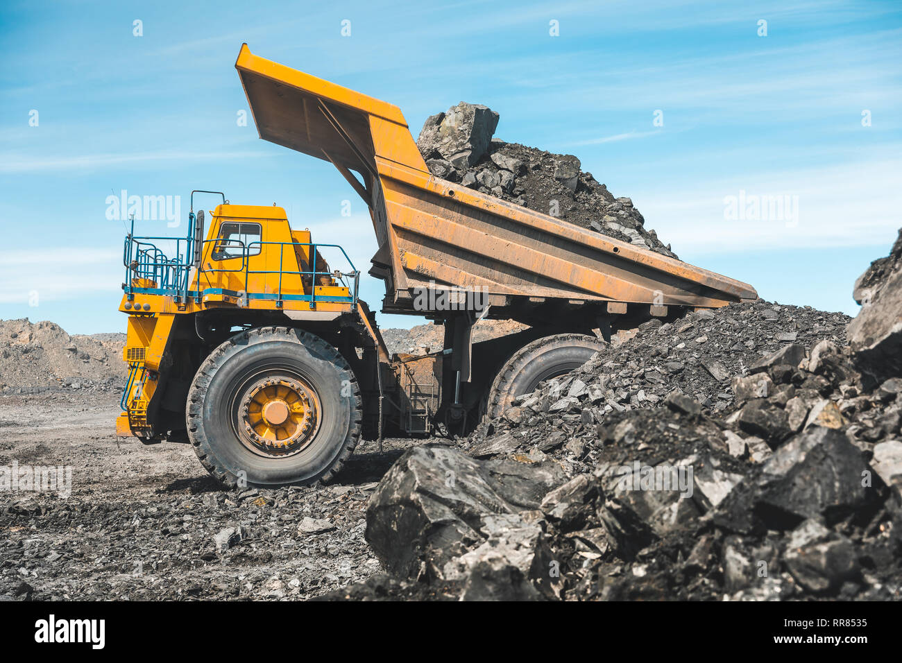 Large quarry dump truck. Loading the rock in dumper. Loading coal into body truck. Production