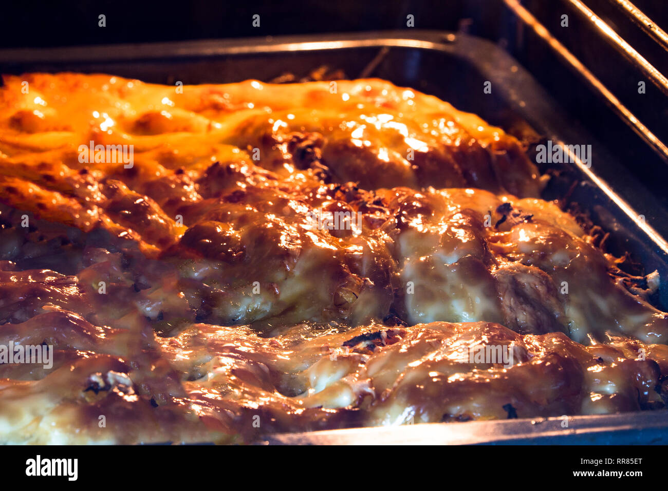 cooking in the oven meat with potatoes under mayonnaise Stock Photo Alamy
