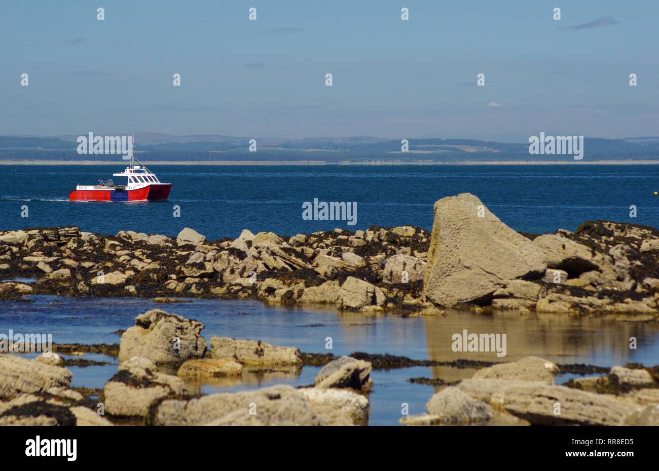 Red Double Hulled Fishing Boat Collecting Lobster Pots by Rugged Wild