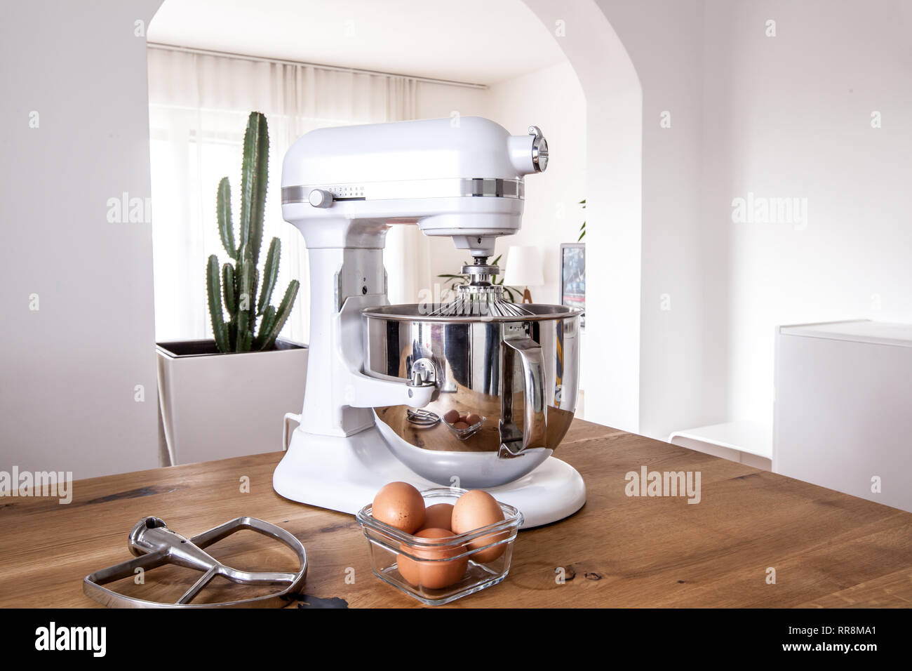 https://c8.alamy.com/comp/RR8MA1/white-kitchen-machine-and-stand-mixer-on-a-wooden-table-in-a-bright-design-apartment-RR8MA1.jpg