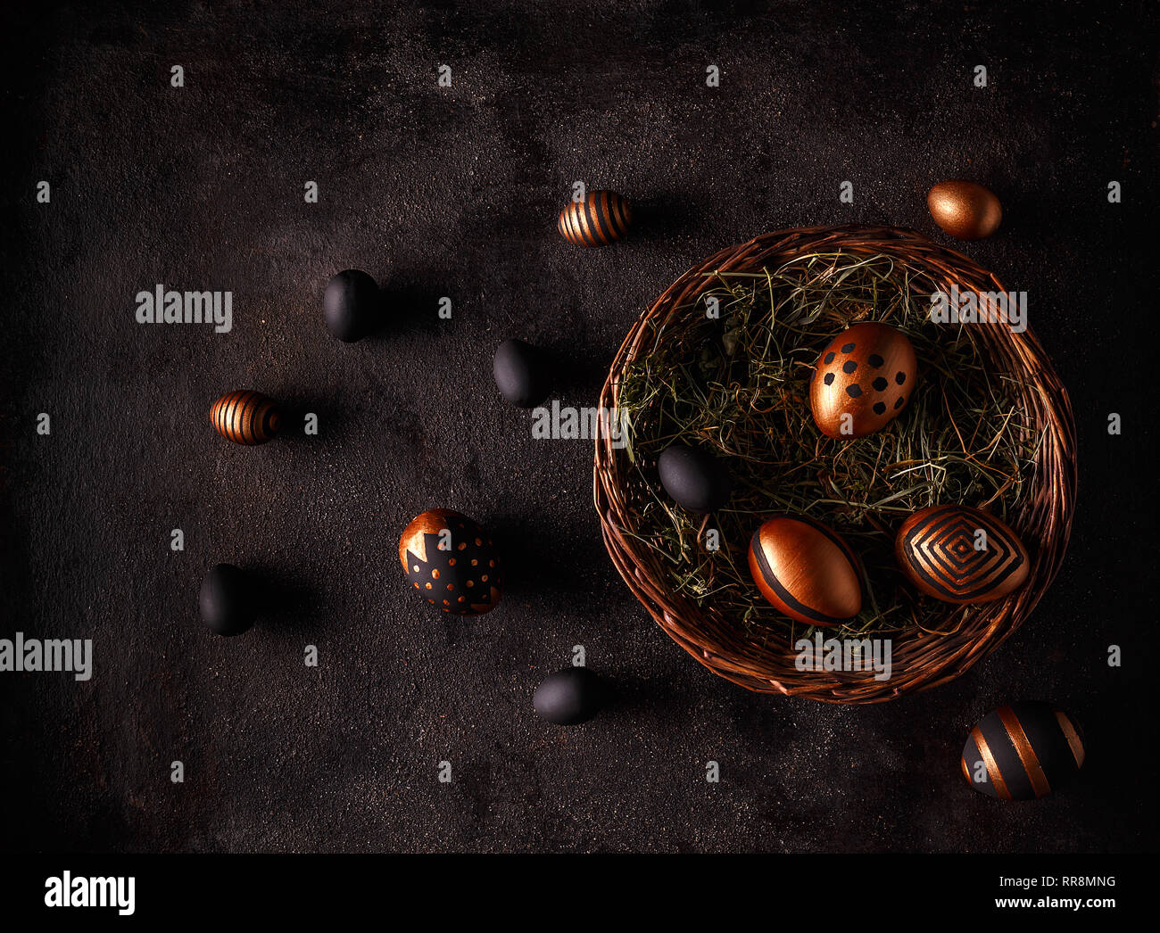 Black and gold eggs over black background. Flat lay Stock Photo