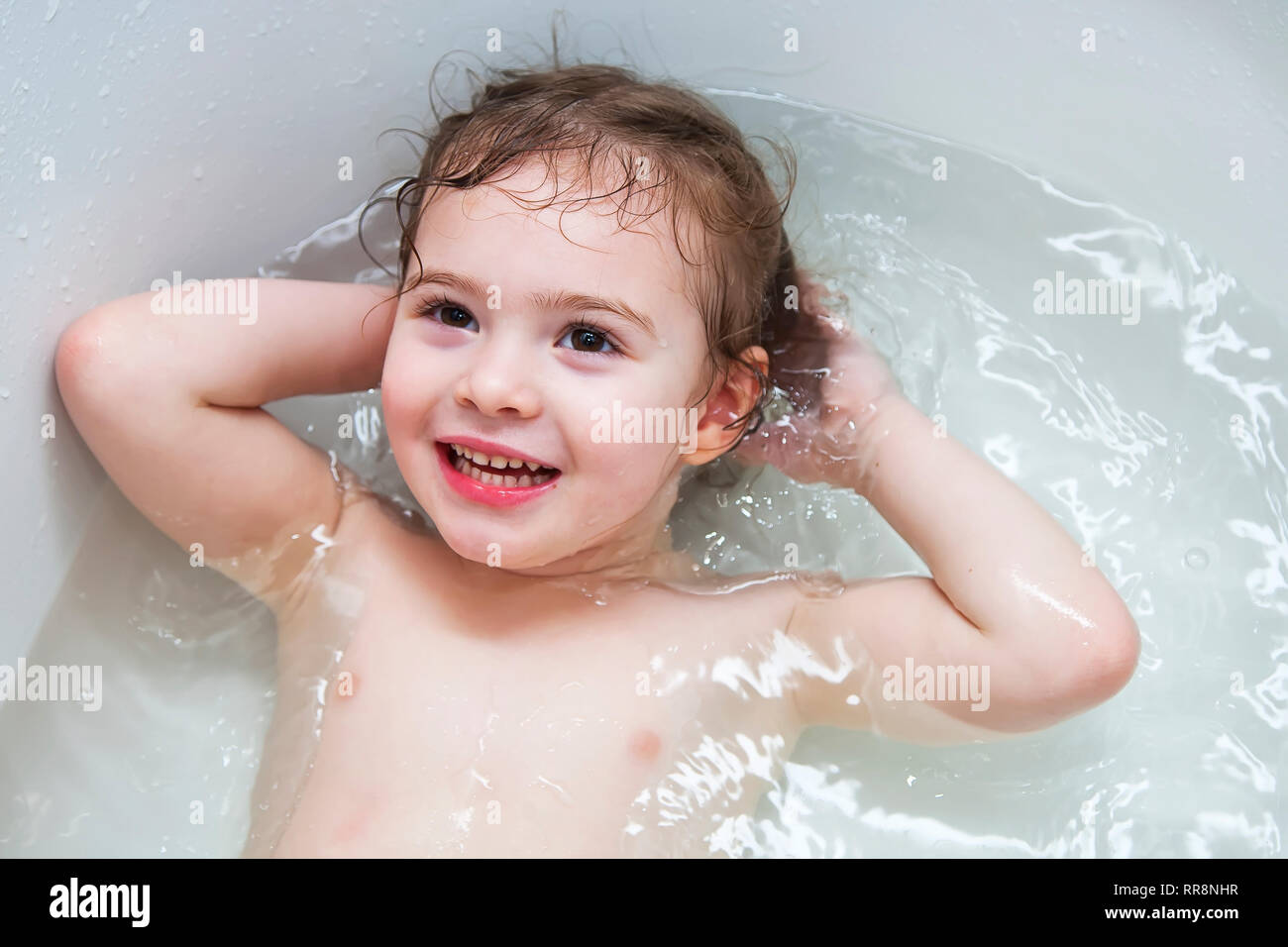 Happy little baby girl face swimming in the bathroom Stock Photo - Alamy