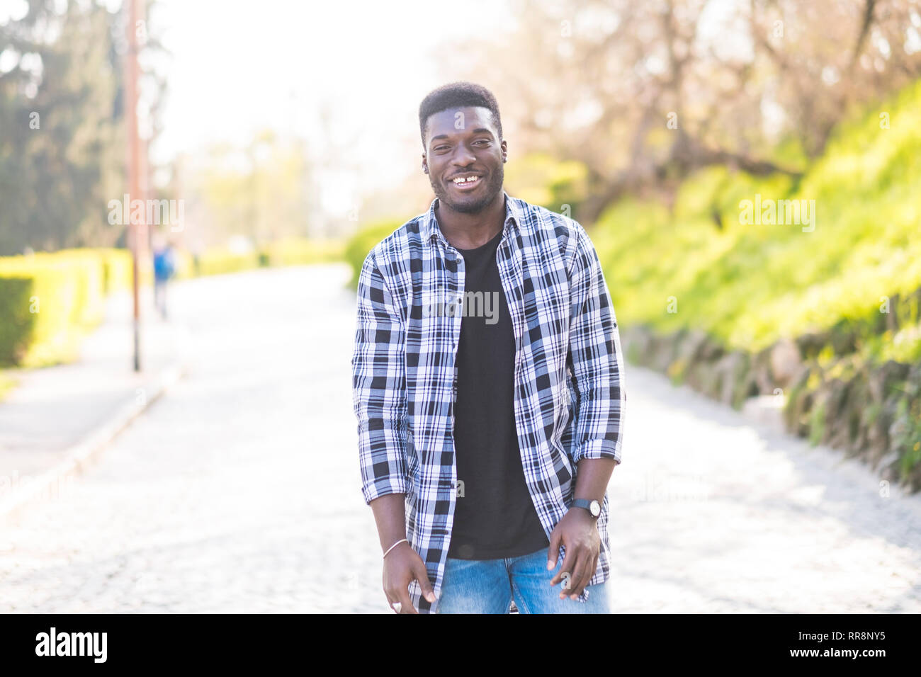 Portrait of black african american young man standing and smiling at ...