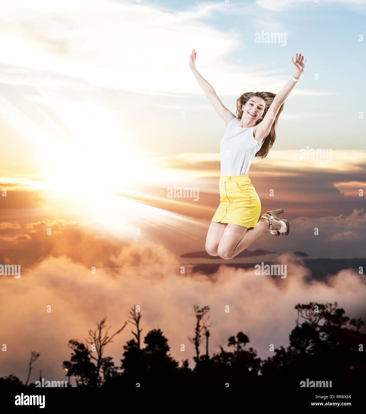 Young woman jumps in the cloudy sky Stock Photo - Alamy