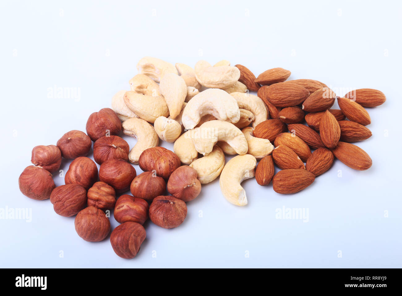 Mixed nuts from hazelnuts, almonds, cashews isolated on white background. Selective focus. Stock Photo