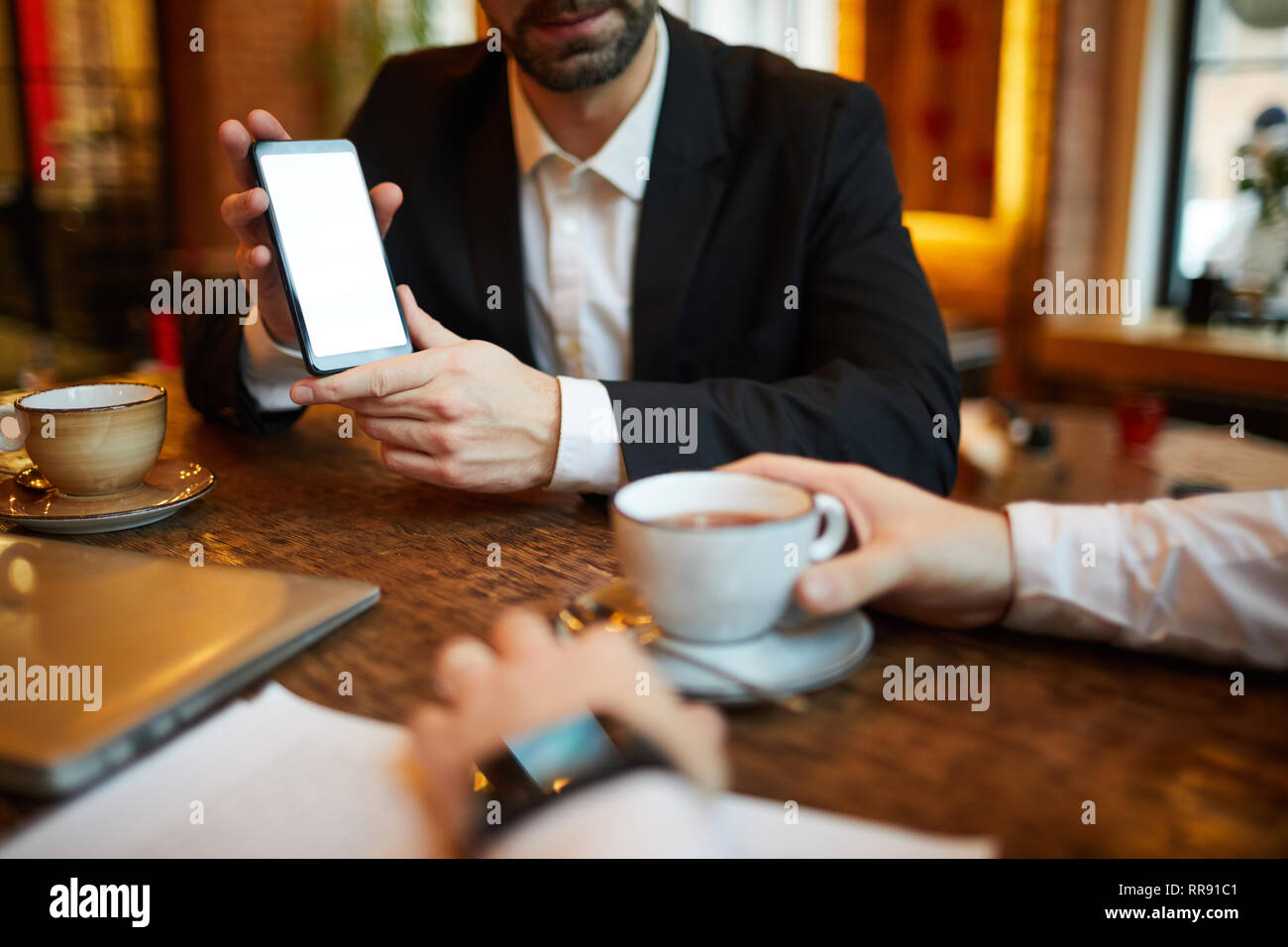 Businesman Presenting Smartphone Stock Photo