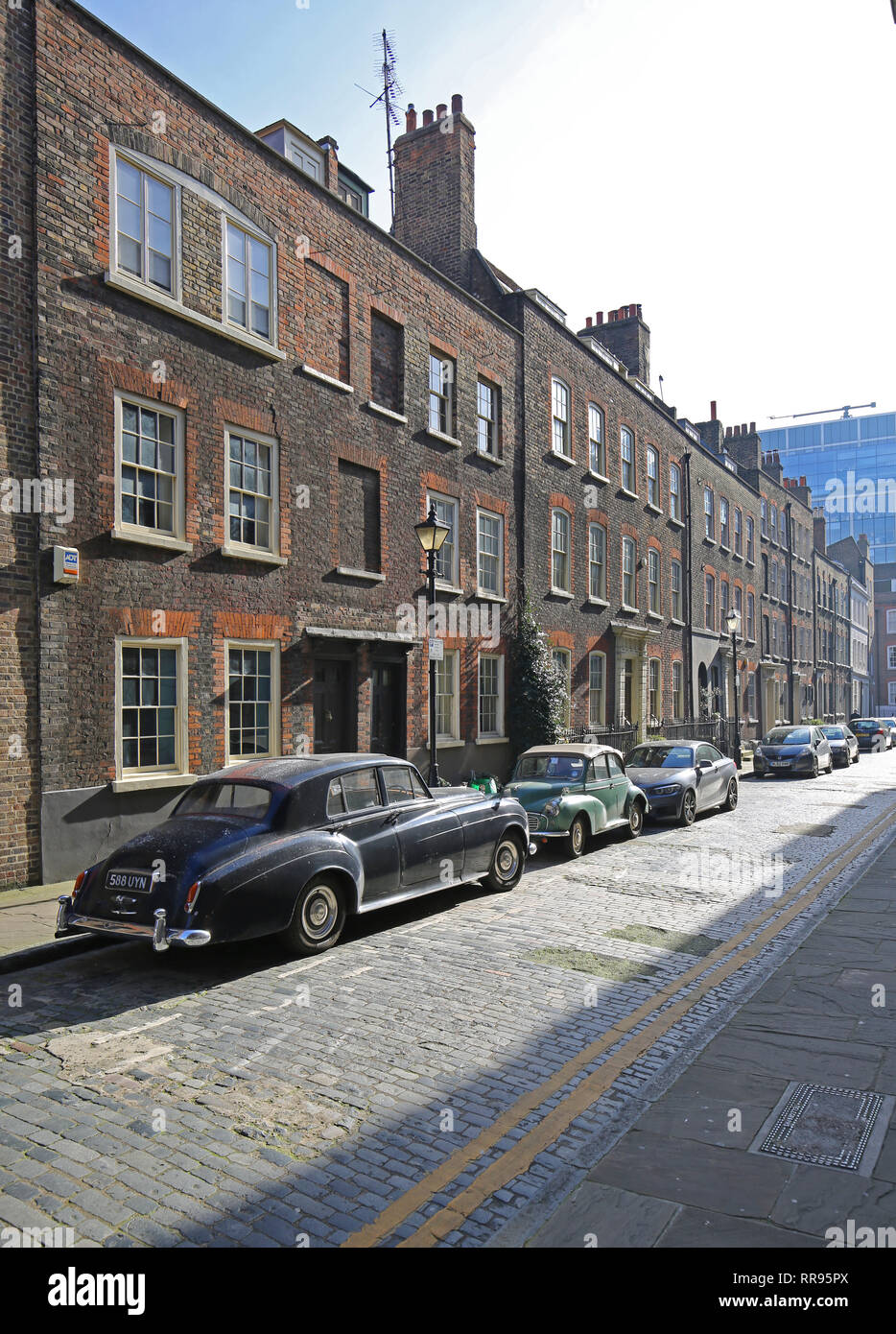 Elder Street in Shoreditch, London, UK. An original Georgian street with cobblestone surface. Dates from 1725. Vintage Bently car in foreground. Stock Photo