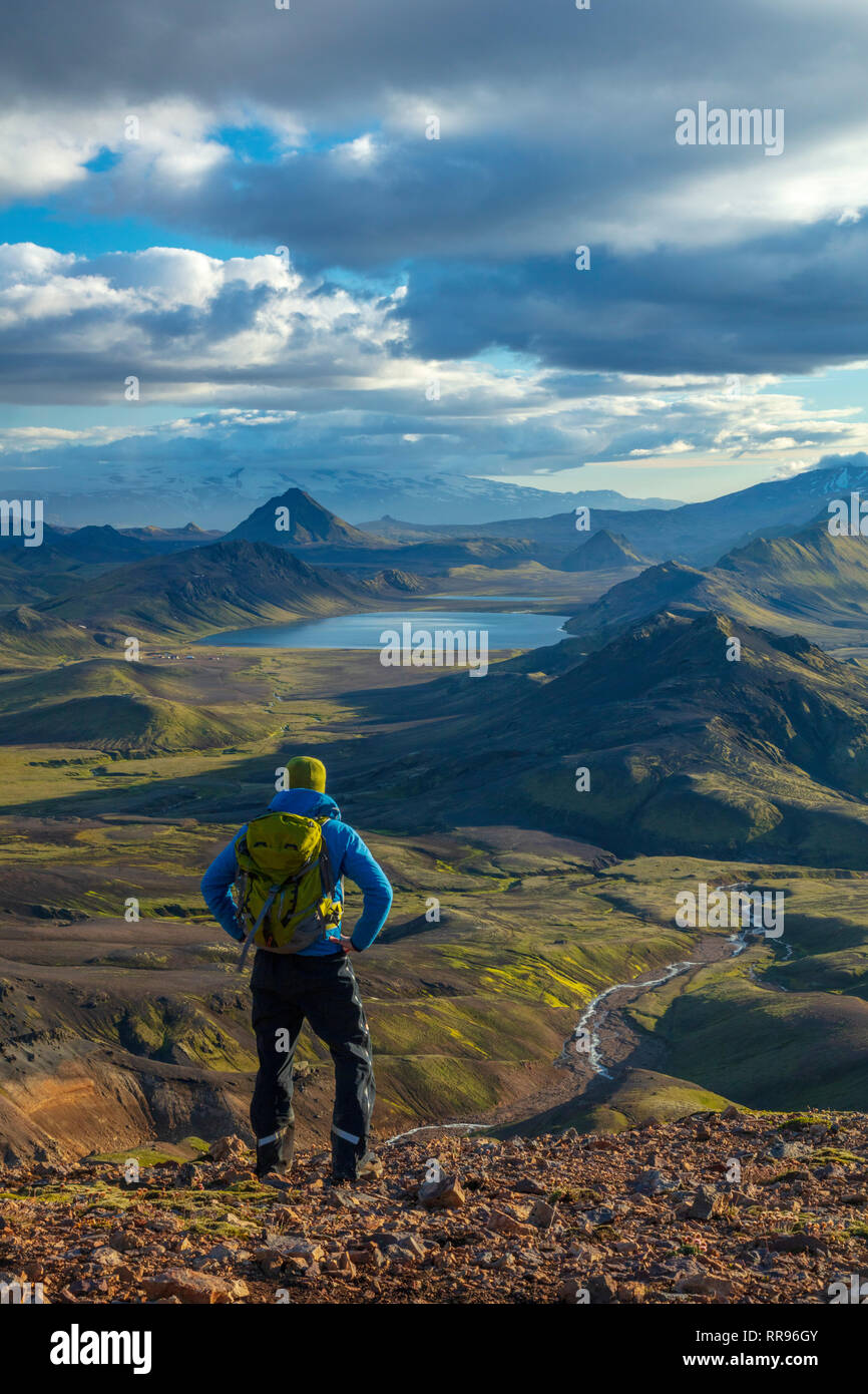 Hiker looking over the mountains and lake at Alftavatn, from Jokultungur on the Laugavegur hiking trail. Central Highlands, Sudhurland, Iceland. Stock Photo
