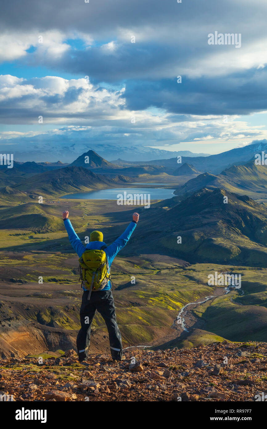 Hiker looking over the mountains and lake at Alftavatn, from Jokultungur on the Laugavegur hiking trail. Central Highlands, Sudhurland, Iceland. Stock Photo
