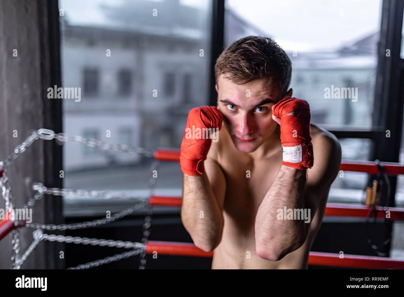 Boxing man with red bandages in the ring Stock Photo