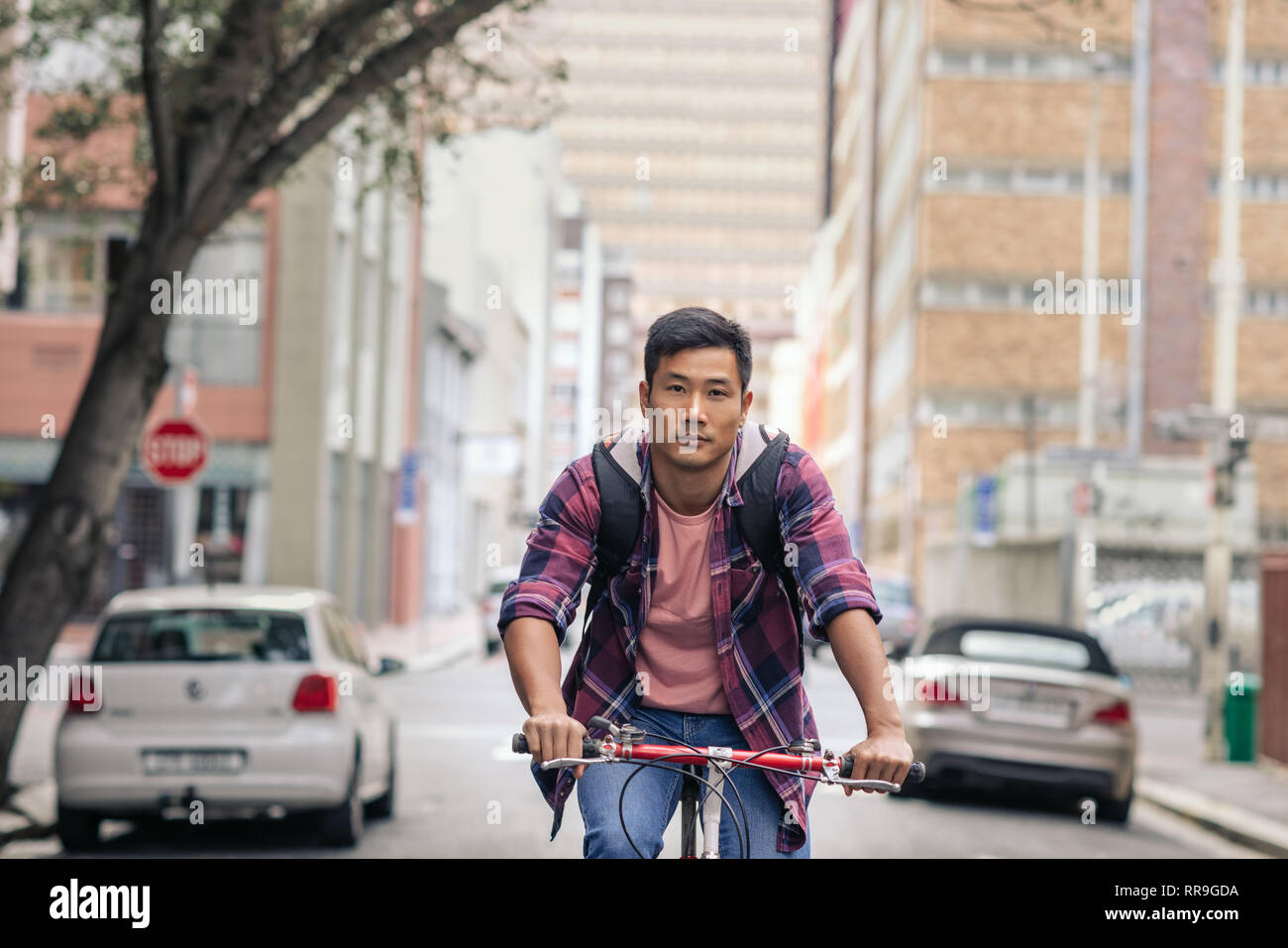Young Asian man riding his bike through the city Stock Photo