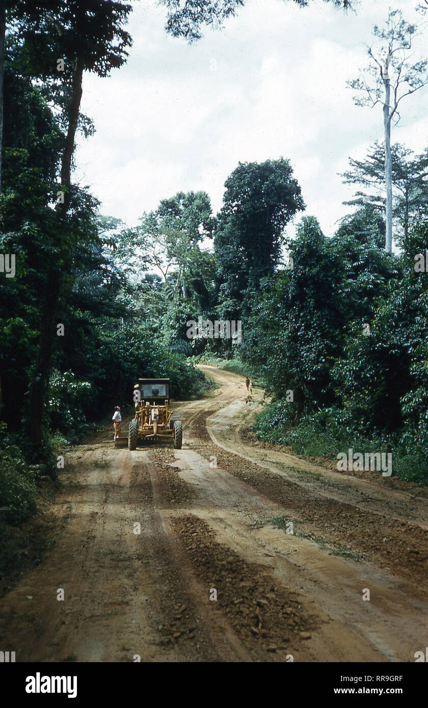 1960s, Ghana, West Africa, a tractor on a newly created sandy covered clearing in the Ghanaian forest. These were made to enable the heavy vehicles and trucks access to remove the timber from the forests which heavily logged in this era, leading to severed deforestation and so eventaully threatening wildlife, ecosystems and weather patterns. Stock Photo