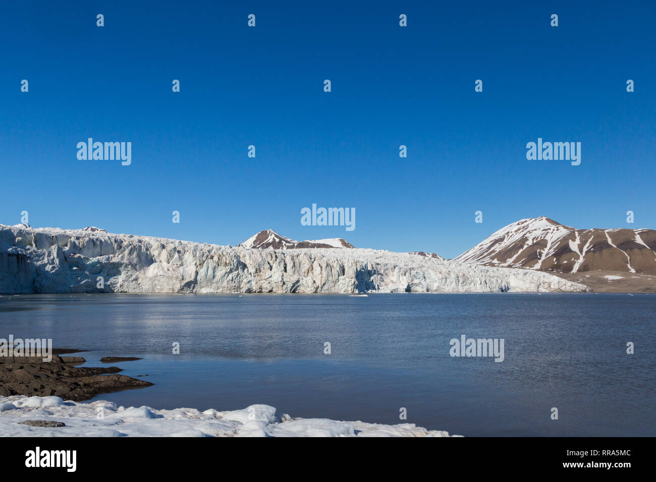 ice front of natural Esmarkbreen glacier in summer, Spitsbergen, blue sky, sea Stock Photo