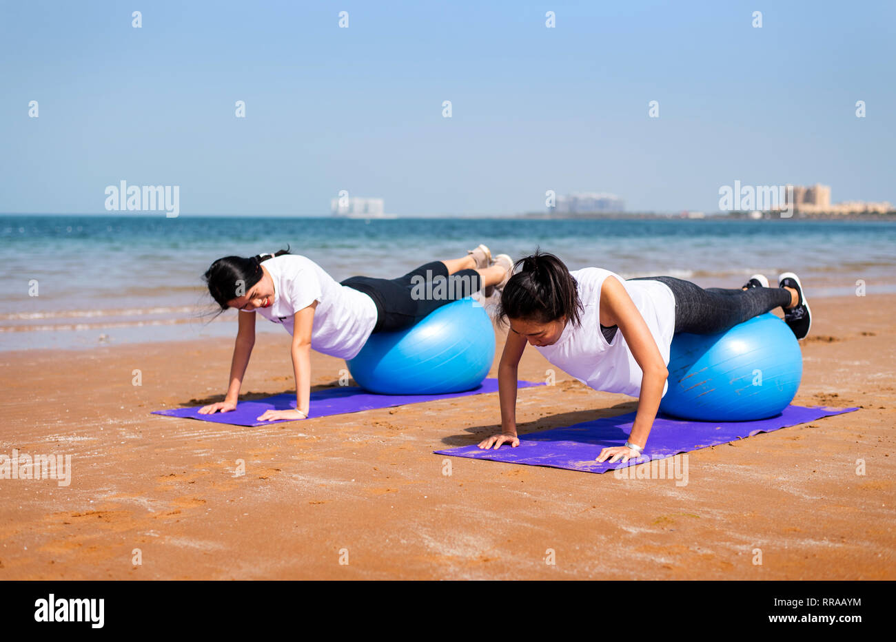Women exercising with pilates yoga ball on the beach Stock Photo
